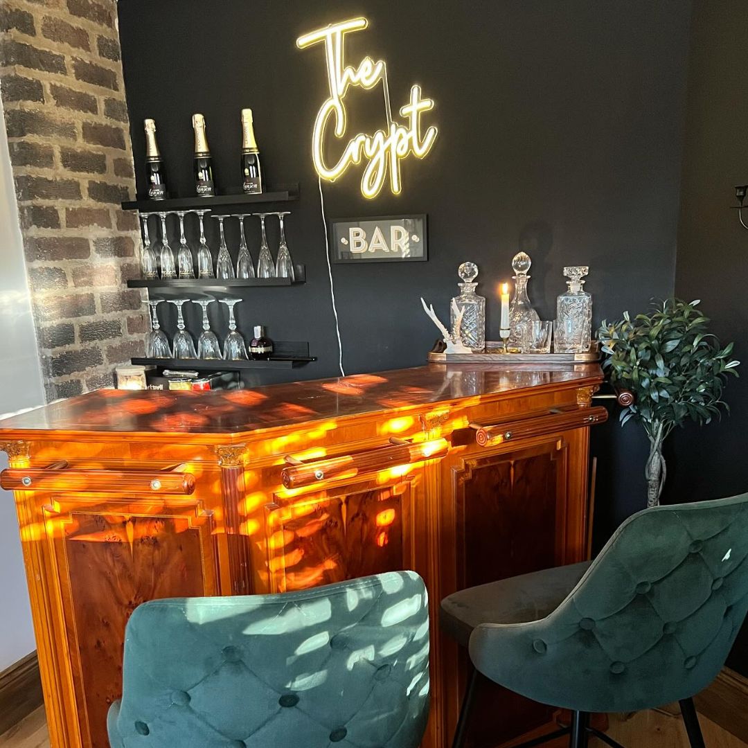 Home bar with real corner bar, glasses on wall, bar stools and white 