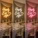 Three vertical panels show a neon wall sign reading “Happily Ever After” with a heart, installed in a decorated event space with floral wallpaper, draped fabric, and a dining table. The left panel is labeled “Cosy Warm White,” the middle “Snow White,” and the right “Pastel Pink,” demonstrating the sign’s color options.