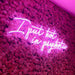 I Put Hot In Psychotic Neon Sign in pink against a pink flowery wall.