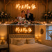 A split-screen collage showing a wedding reception head table scene above and a matching bedroom below. The top panel shows a bride and groom seated at a decorated table with a glowing neon sign reading “Mr & Mrs Iffle” on the wall.