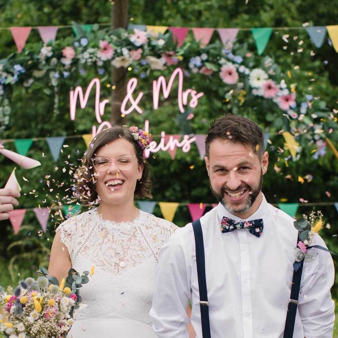 Pink Surname Wedding Neon Sign couple with confetti.jpg__PID:2449e8fd-d379-4f11-837f-682ee5ad5132