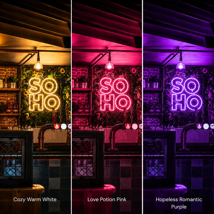 Three vertical panels show a neon-style 'SO HO' neon sign mounted in a bar or kitchen setting, each lit in a different colour mode: Cozy Warm White, Love Potion Pink, and Hopeless Romantic Purple. The neon sign glows brightly against dark shelving and tiled walls, with hanging bulbs above.