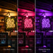 Three vertical panels show a neon-style 'SO HO' neon sign mounted in a bar or kitchen setting, each lit in a different colour mode: Cozy Warm White, Love Potion Pink, and Hopeless Romantic Purple. The neon sign glows brightly against dark shelving and tiled walls, with hanging bulbs above.