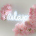 White Relax Neon Sign by  Jaclyn Moss Salon & Training Academy