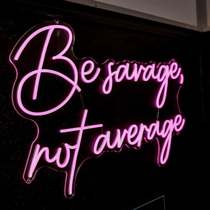 Be Savage, Not Average Neon Sign in love potion pink. Photo by CrossFit Alhaurin