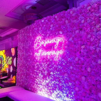Be Savage, Not Average neon sign in love potion pink. Photo by Icon Events