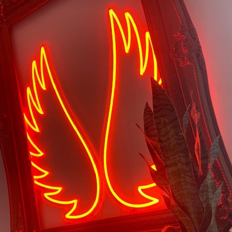 Red angel wings neon sign in frame