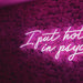 I Put Hot In Psychotic Neon Sign in pink against a pink flowery wall.