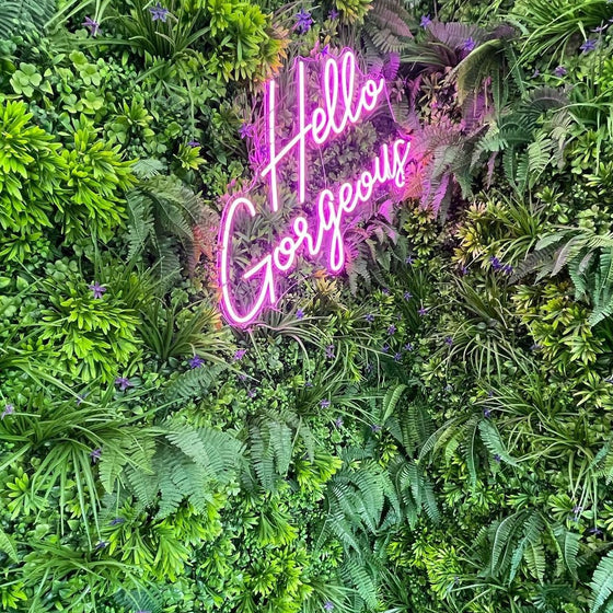 Pink Neon Sign on artificial plant wall