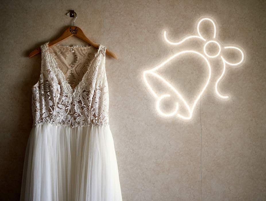 Snow white neon bel sign against a white wedding dress