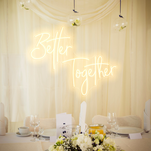Warm white better together sign against a white fabric backdrop 