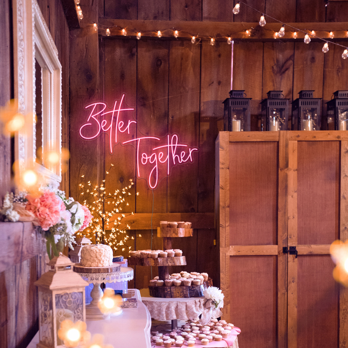 Pink "Better Together" neon sign at wedding ceremony