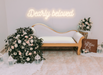 Warm white dearly beloved sign with classy sofa and floral bouquet
